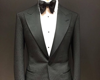 May include: A black tuxedo jacket with a satin lapel and a black bow tie. The jacket has a textured pattern and a single button closure.