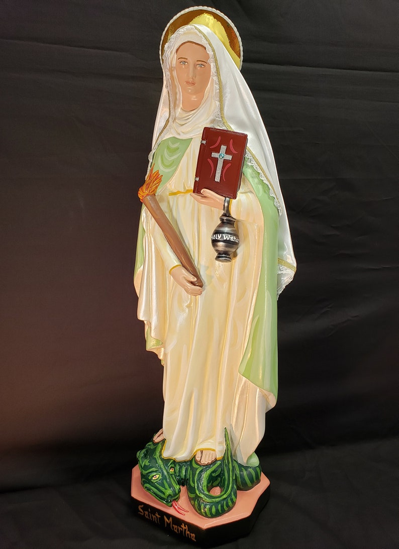 Pu&ograve; includere: Statua di Santa Marta, raffigurata in abiti fluenti con un'aureola. Tiene in mano una torcia e un libro con una croce, e si erge su un drago verde. La base &egrave; incisa con "Saint Martha".