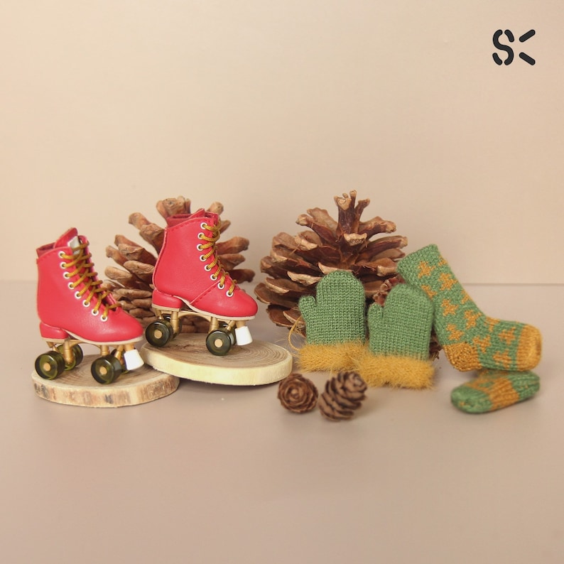 May include: A pair of red roller skates with gold wheels and white stoppers.  Two green and yellow knitted mittens with fuzzy trim.
