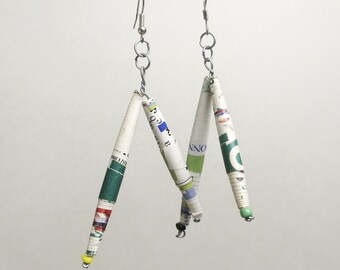 May include: A pair of earrings made from rolled up pieces of paper with green, blue, and red accents. The earrings are suspended from silver hooks.