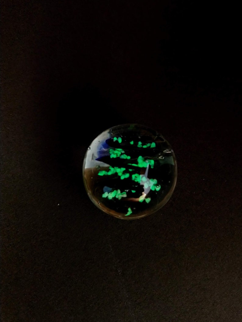May include: A clear glass paperweight with green and blue glitter inside.