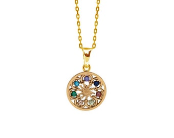 May include: Gold necklace with a round pendant featuring a detailed design and colorful gemstones.