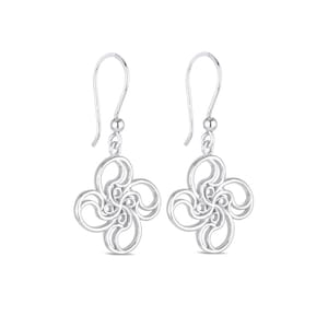 May include: Silver dangle earrings with a delicate, intricate design resembling a flower or a stylized knot. The earrings have a simple hook closure.