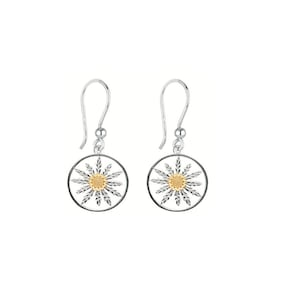 May include: Silver dangle earrings with a round, openwork design featuring a gold center. The design resembles a stylized flower.
