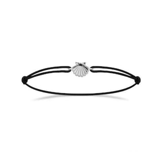 Könnte beinhalten: Ein schwarzes Armband aus Schnur mit einem silbernen Muschel-Anhänger.