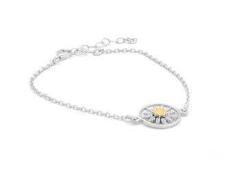 May include: A silver chain bracelet with a round pendant featuring a stylized flower with a gold center.