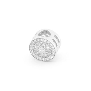 May include: A silver charm featuring a circular design with a flower, a clear crystal centre and smaller crystals around it. The charm has a small loop at the top for attaching to a bracelet or necklace.