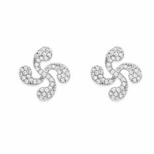 May include: A pair of silver-toned stud earrings featuring a four-armed curved design, known as a Lauburu, completely encrusted with small, clear, sparkling round stones that cover the entire surface of each earring piece.