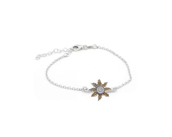 May include: A silver chain bracelet with a gold and silver flower charm.
