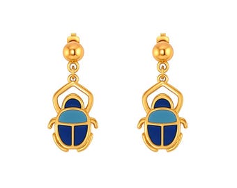May include: A pair of gold-toned drop earrings featuring a beetle-shaped pendant. The beetle design is accented with inlaid enamel sections in two distinct shades of blue, specifically a lighter sky blue and a deeper navy blue color.