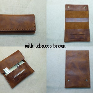 May include: A brown leather cigarette case with a flap closure and a stitched design. The case is open to reveal a compartment for cigarettes and a smaller compartment for a lighter or other small items. The case is labeled "with tobacco brown".