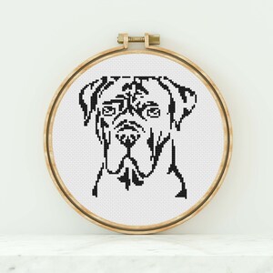 May include: Black and white cross-stitch embroidery of a Great Dane dog's head in a wooden embroidery hoop.