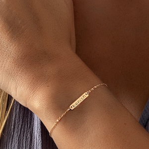 a close up of a person wearing a gold bracelet