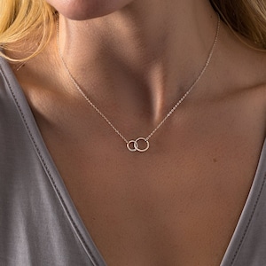 a woman wearing a necklace with a circle on it