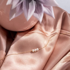 a close up of a necklace on a satin material