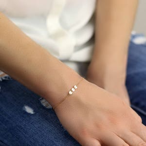 a woman's hand with a gold bracelet on it