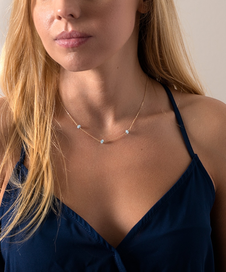 a woman wearing a blue top and a necklace