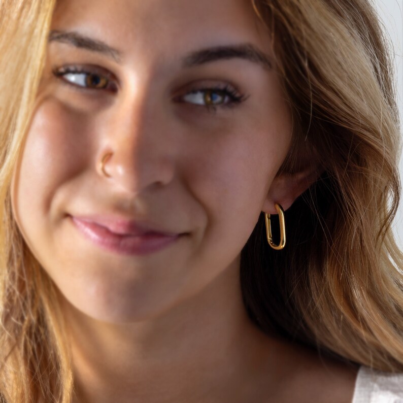 a close up of a person wearing a pair of earrings