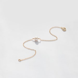 a necklace with a pearl and a gold chain