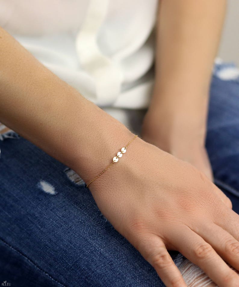 a woman's hand with a gold bracelet on it