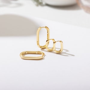 a pair of gold earrings sitting on top of a table