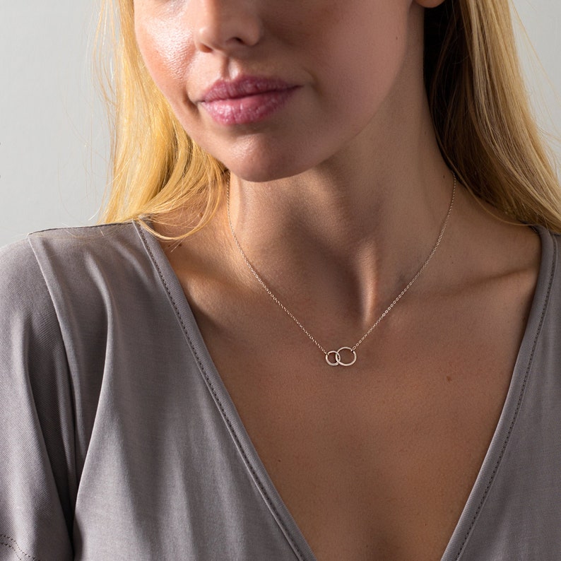 a woman wearing a necklace with a circle on it