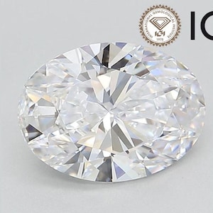 May include: A clear oval-shaped diamond with a brilliant cut. The diamond is set in a ring and is surrounded by a silver band.