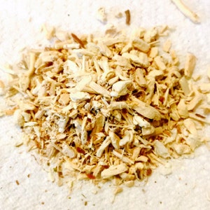 May include: A pile of dried, light brown, shredded ginger root.