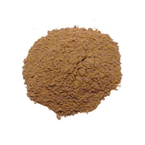 May include: A close-up of a pile of brown powder. The powder is finely ground and has a slightly reddish hue.