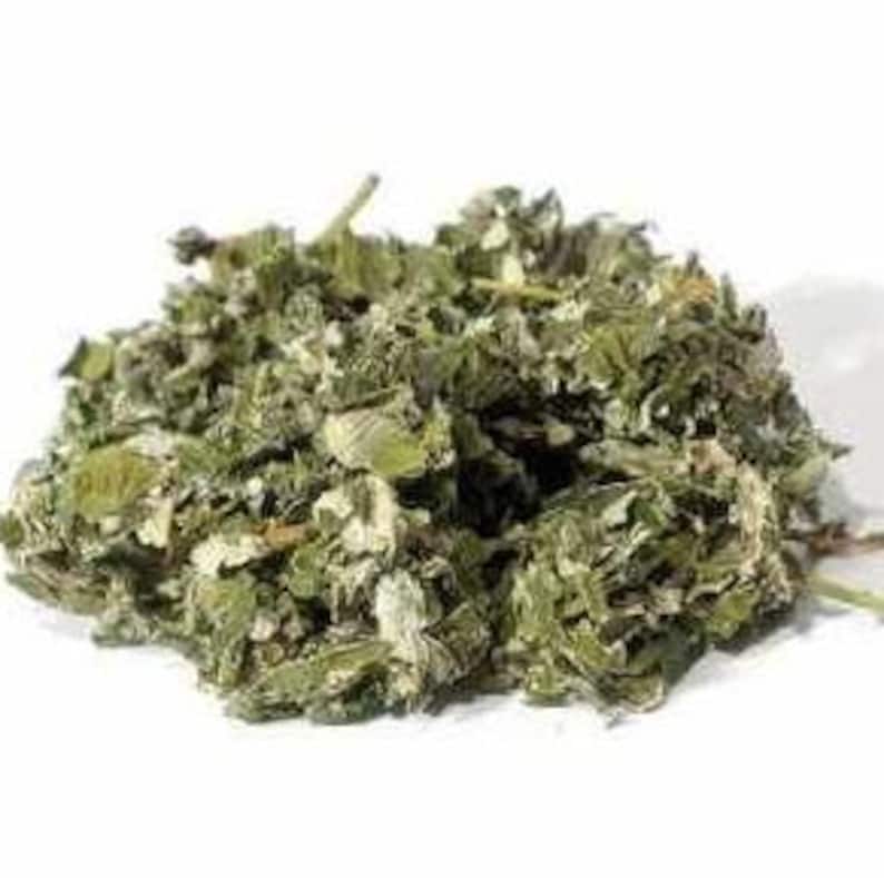 Op de afbeelding: Gedroogde groene en witte kruidenbladeren, een natuurlijk ingredi&euml;nt voor kruidenthee en remedies.