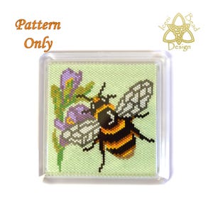 May include: A square, clear acrylic magnet with a cross-stitch design of a bumblebee and purple flowers on a light green background. The text "Pattern Only" is in orange script. The design is by Iceni Bead Design.
