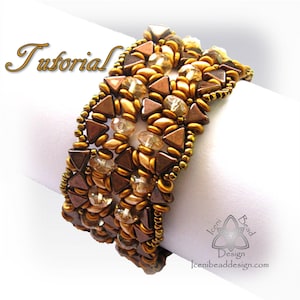 Può includere: Bracciale di perline con un design geometrico nei toni del marrone e dell'oro, con dettagli trasparenti. Il design incorpora forme triangolari e arrotondate. La parola "Tutorial" è visibile. Il bracciale è presentato su sfondo bianco.