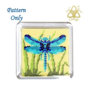 May include: A square, clear acrylic block featuring a beaded dragonfly design. The dragonfly is blue and black, set against a yellow background with green grass. The text "Pattern Only" is in the upper left corner.