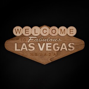 May include: Wooden sign featuring the iconic "Welcome to Fabulous Las Vegas Nevada" design. The sign is made of light brown wood with the text in a lighter shade. The word "WELCOME" is in individual circular letters.