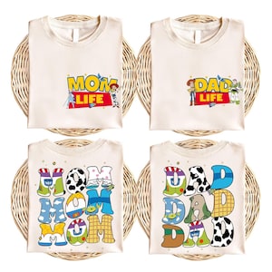 four different t-shirts, each with a unique design related to the characters from the Toy Story movie. The t-shirts feature the characters Mom, Dad, and various other characters from the film, along with the words "MOM LIFE" and "DAD LIFE" printed on them.