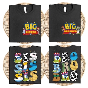 four black t-shirts with colorful text and characters, including the characters from the Toy Story franchise. The t-shirts are arranged in a grid-like pattern, with each shirt having a different design.