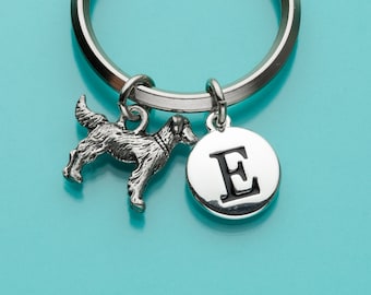 May include: Silver keychain with a dog charm and a silver charm with the letter E in black.