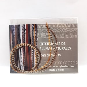 Puede incluir: Dos mechones de extensiones de pelo de plumas marrones y beige en una bolsa de plástico transparente con una tarjeta blanca que dice "EXTENSIONES DE PLUMAS NATURALES 100% ORIGINALES Lavar - peinar - planchar - rizar Hasta 6 meses"