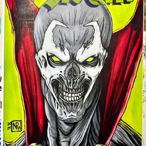 May include: A black and white illustration of Spawn, a comic book character, with a red cape and a skull on his chest. The background is yellow with the word "SPAWN" in green letters.