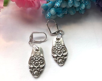 May include: A pair of silver earrings with a floral design. The earrings are made from repurposed silverware and have a delicate, feminine look.
