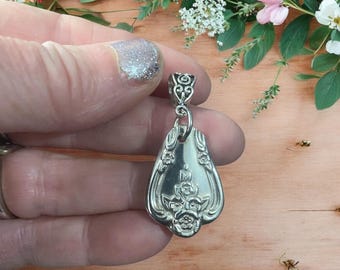 Puede incluir: Encanto de colgante de plata con un diseño floral, hecho de una cuchara vintage reutilizada. El colgante tiene forma de lágrima y tiene un aro para sujetarlo a un collar o pulsera.