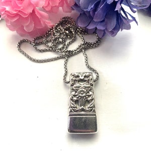 May include: A silver chain necklace with a pendant made from a vintage silverware piece. The pendant features an ornate floral design.