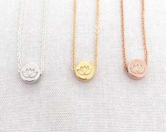 May include: Three delicate necklaces with a lotus flower pendant. The necklaces are silver, gold, and rose gold.