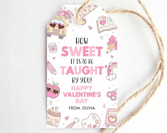 以下が含まれることがあります： ピンクと黄色のスクールバス、ハート、そして「How Sweet It Is To Be Taught By You! Happy Valentine's Day From Olivia」というテキストが書かれた白いギフトタグ。茶色の紐がタグに付いています。