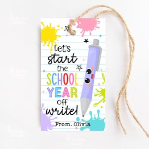 Puede incluir: Una etiqueta de regalo con temática escolar con una ilustración de un bolígrafo de dibujos animados. La etiqueta presenta el texto "Let's start the SCHOOL YEAR off write!" en varios colores, con un mensaje "From. Olivia" en la parte inferior. La etiqueta está decorada con salpicaduras de pintura coloridas y una cuerda.