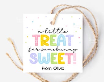 以下が含まれることがあります： カラフルな文字で「a little TREAT for somebunny SWEET！」と書かれた正方形の白いギフトタグ。タグは天然の麻ひもで結ばれており、パステルカラーの紙吹雪のドットが付いています。