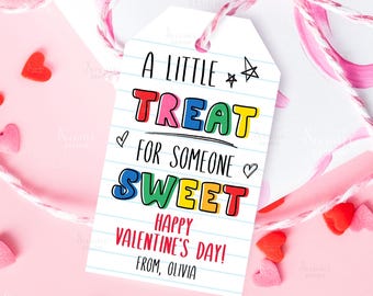 May include: A Valentine's Day gift tag with the text "A Little Treat For Someone Sweet." The tag is white with blue lined paper design and colorful text. Pink and white twine is tied around the gift, with heart-shaped candies scattered around.