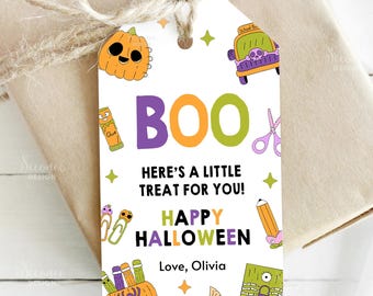 May include: A white Halloween gift tag with the word "BOO" in purple, orange, and green. The tag features cartoon illustrations of a pumpkin, school bus, scissors, and other school supplies. The text "HERE'S A LITTLE TREAT FOR YOU! HAPPY HALLOWEEN Love, Olivia" is also included.