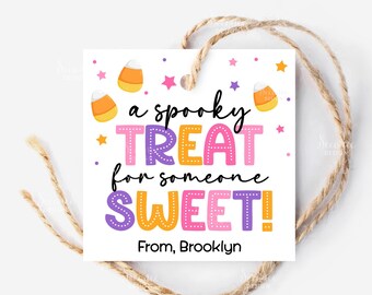 May include: A white square gift tag with the text "a spooky TREAT for someone SWEET!" in colorful letters. The tag is decorated with candy corn and stars, and has a twine string attached. The tag reads "From, Brooklyn".
