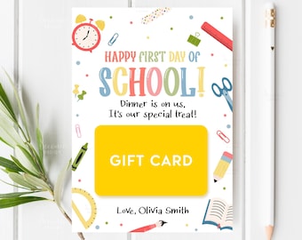 Könnte beinhalten: Eine weiße Geschenkkarte mit dem Text "HAPPY FIRST DAY OF SCHOOL!" in bunten Buchstaben. Die Karte hat Illustrationen zum Thema Schule wie eine Uhr, eine Schere und einen Bleistift. Der Text "GIFT CARD" befindet sich in einem gelben Rechteck.